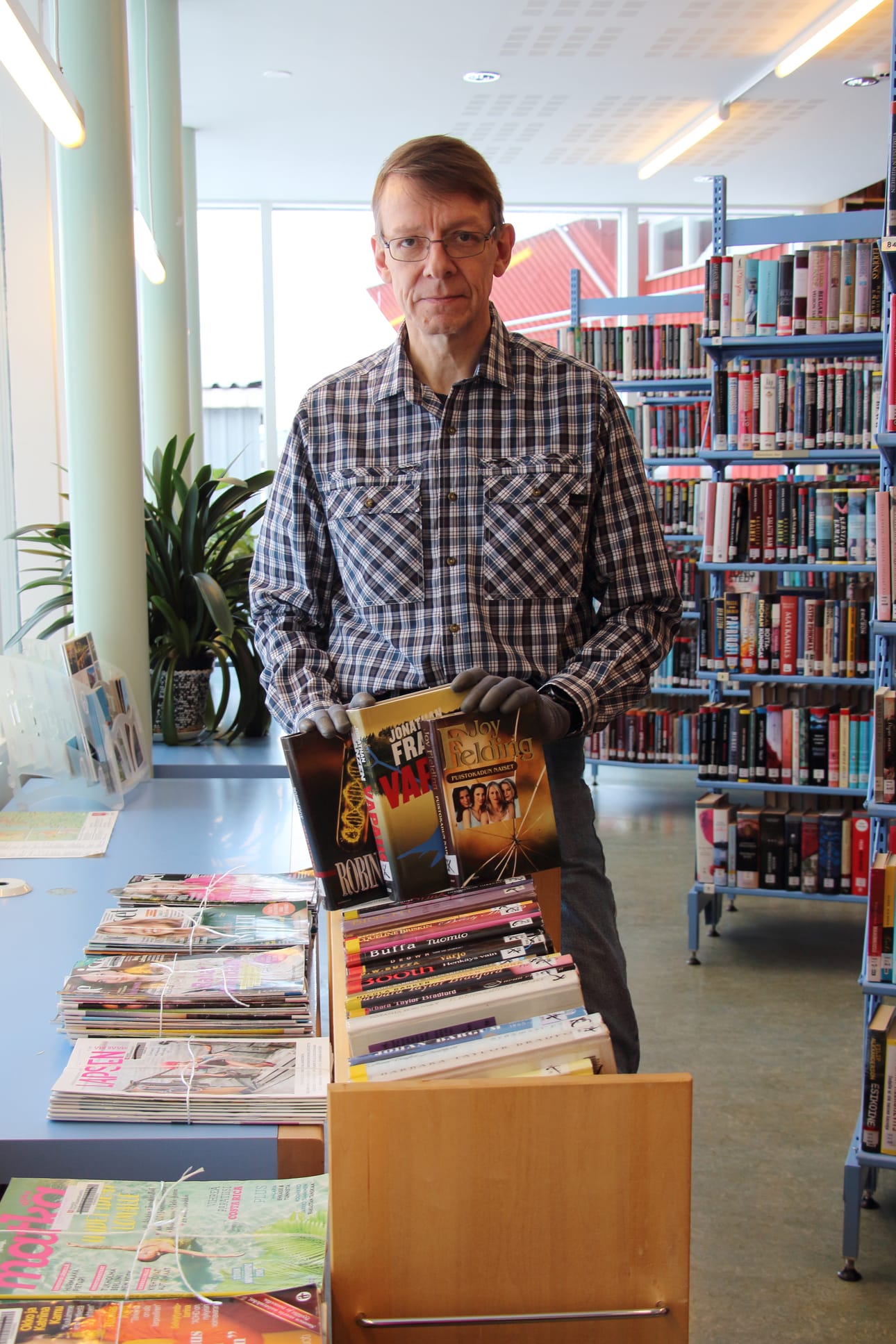 Vihannin kirjastonhoitaja Toni Kykyri täydentää kirjaston poistomyyntipistettä.