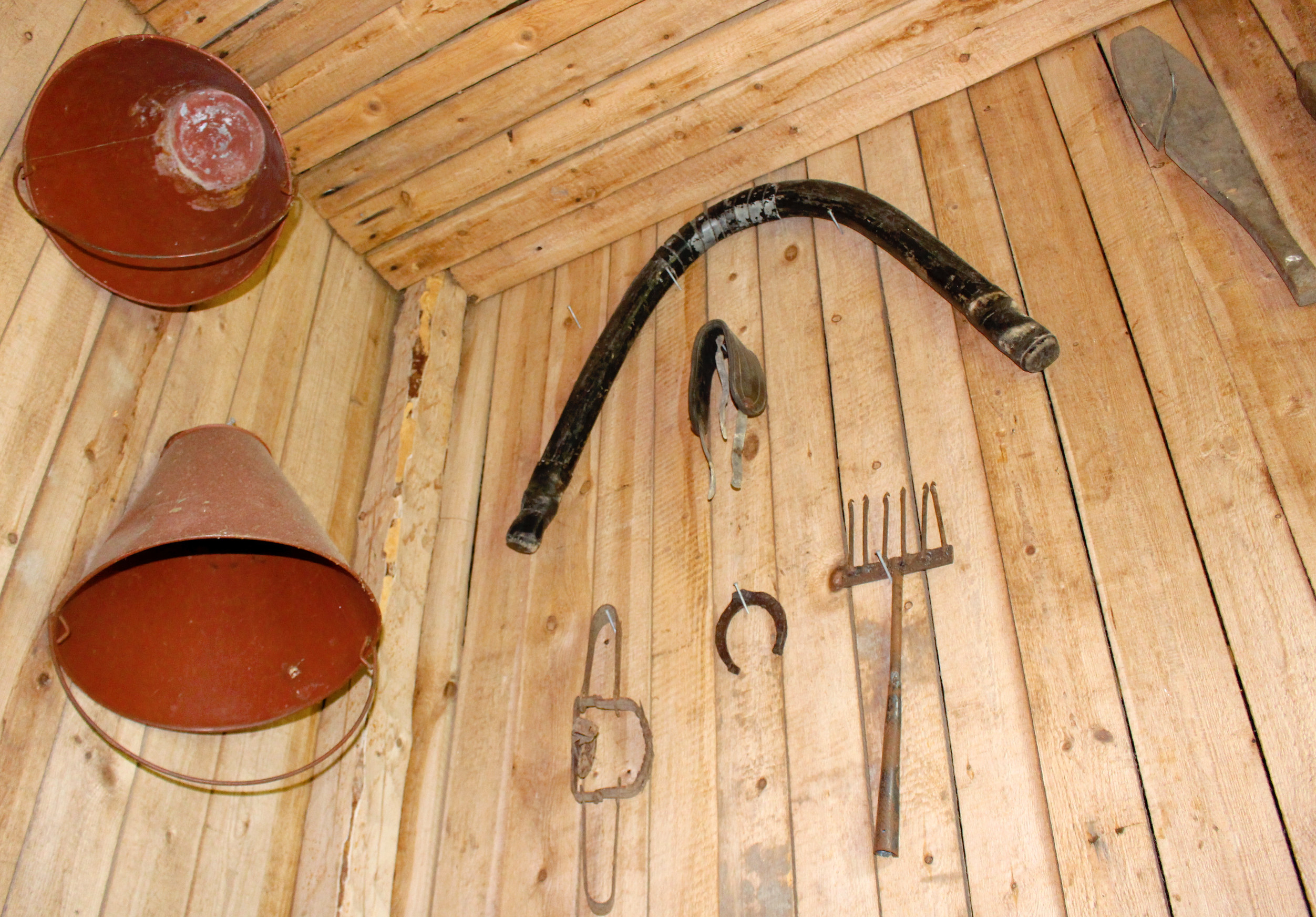 Seinälle on nostettu talteen pihapiiristä löytynyttä esineistöä kuten tulipalon varalle hankitut sangot. Mitähän koulussa tehtiin ketunraudoilla ja atraimella?