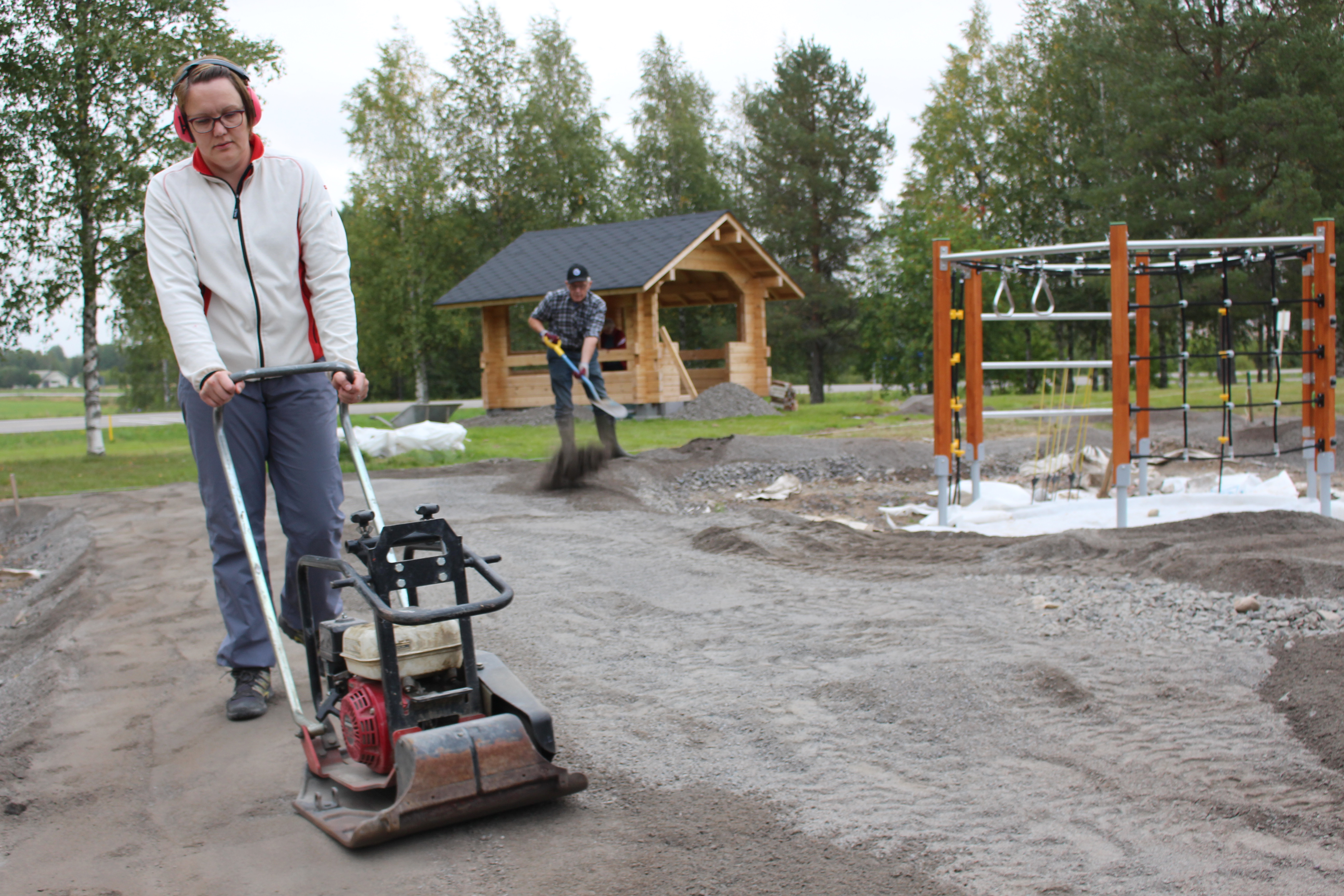 Puistoa on rakennettu pitkin kesää talkoilla. Torstaitalkoissa Elina Alasalmen vastuulla olivat tiivistystyöt kun Tapani Alasalmi levitti mursketta lapiolla.