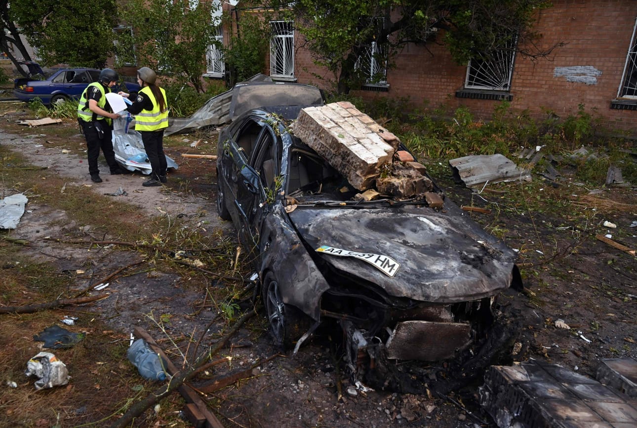 Poliisit tutkivat torstaina ohjushyökkäyksen jälkiä teollisuusalueella Kiovan lähellä. LEHTIKUVA/AFP