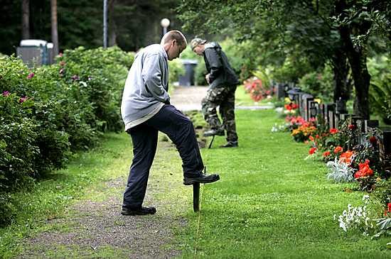 Kesätyöläiset Jari Rautava (edessä) ja Toni Manninen siistivät Oulussa Intiön hautausmaan kulkuväyliä.