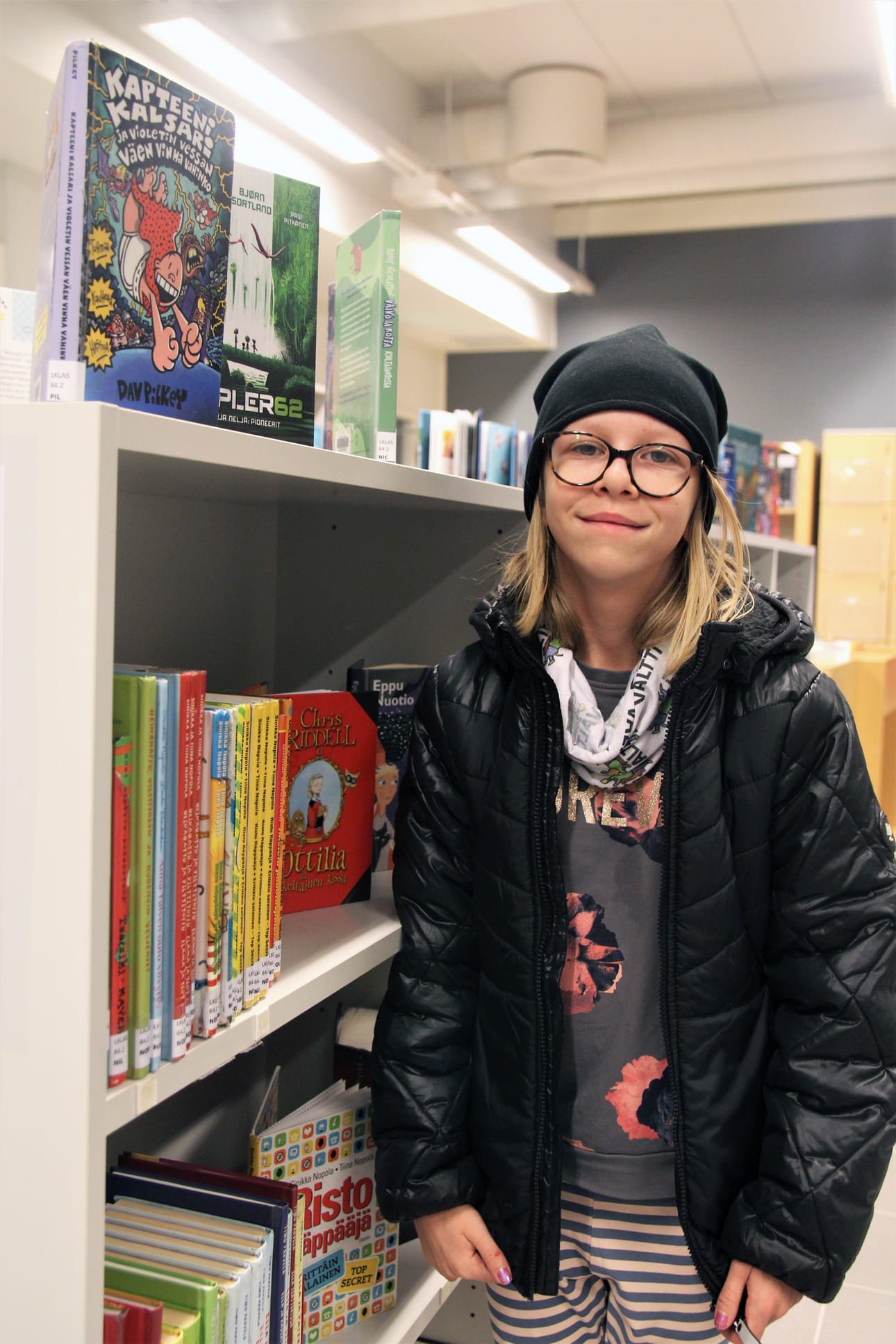 Silja Vedenoja lainaa lastenkirjoja Linnakangastalon omatoimikirjastosta aktiivisesti. Pienestä kirjastosta on helppo löytää haluamansa, joskin kauhutarinakokoelma voisi olla isompikin.