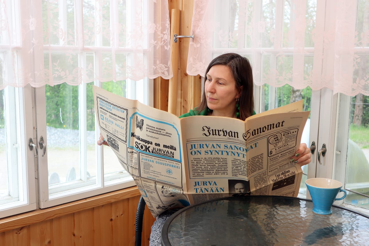 Jurvan Sanomien päätoimittaja Leena Nyysti lukee ensimmäisiä Jurvan Sanomia vuodelta 1976.