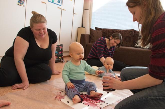 Niilo Vilponen odottaa, kun Anneli Niemistö laittaa uutta väriä paperille. Niilon äiti Elina Korhonen seuraa tilannetta. Takana väripuuhissa Onni ja Heidi Viitanen. Kuvat: Aune Waronen