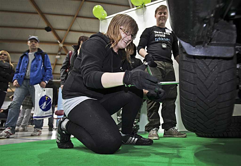 Marjo Myllykangas osallistui Eteenpäin-messuilla renkaanvaihtohaasteeseen. OSAO:n Mikko Manninen (oik.) antaa neuvoja ja ottaa sekuntikellolla aikaa. "En usko, että vaihdat rengasta ekaa kertaa. Niin hienosti menee," Manninen kehuu.