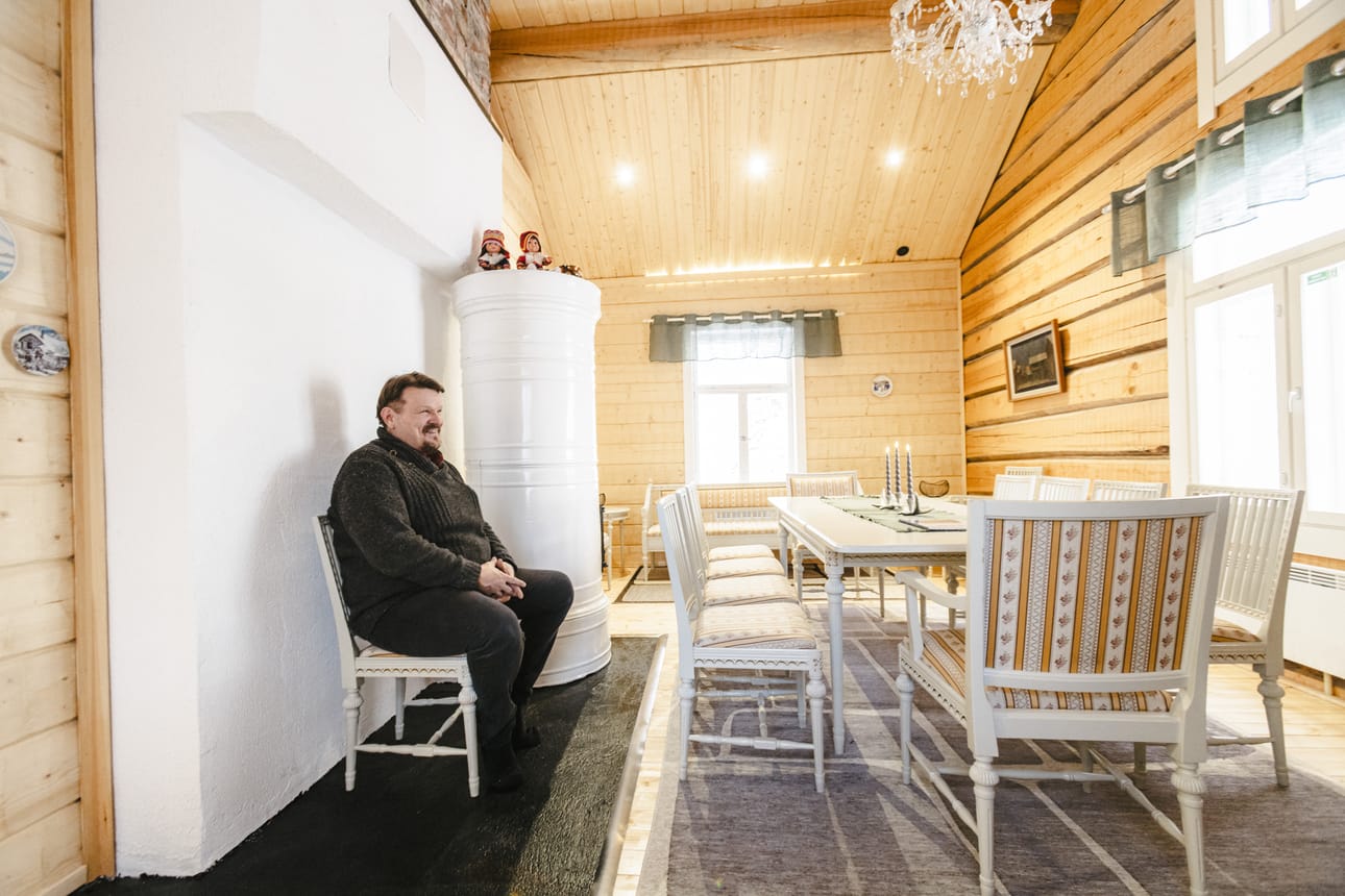 Eero Kajula istuu tyytyväisenä remontoimassaan Punaisessa tuvassa. Huone tuhoutui lähes tyystin tulipalossa vuonna 2023.
