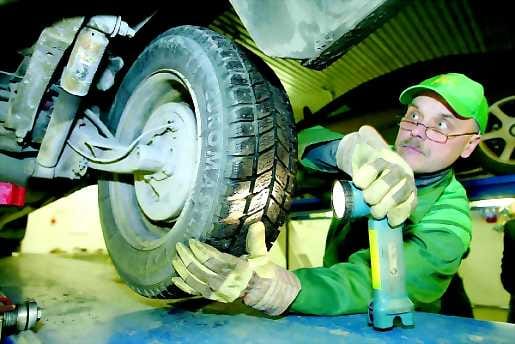 Tarkka syyni tarpeen. Teknikko Heikki Mannila tutkii Konetien Katsastus Oy:ssä autoa tärkeästä suunnasta.