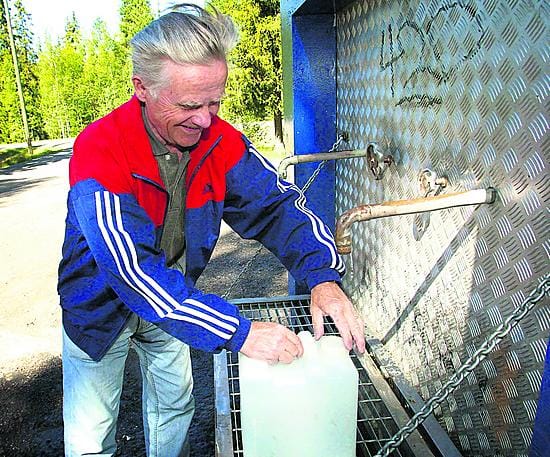 Oululainen Väinö Pekkala hakee pohjavesipostilta juomaveden.