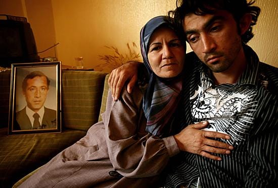 Libanonilaispariskunta istuu lähellä kuvaa, joka esittää Israelin iskussa Baalbekissä kuollutta sukulaista.