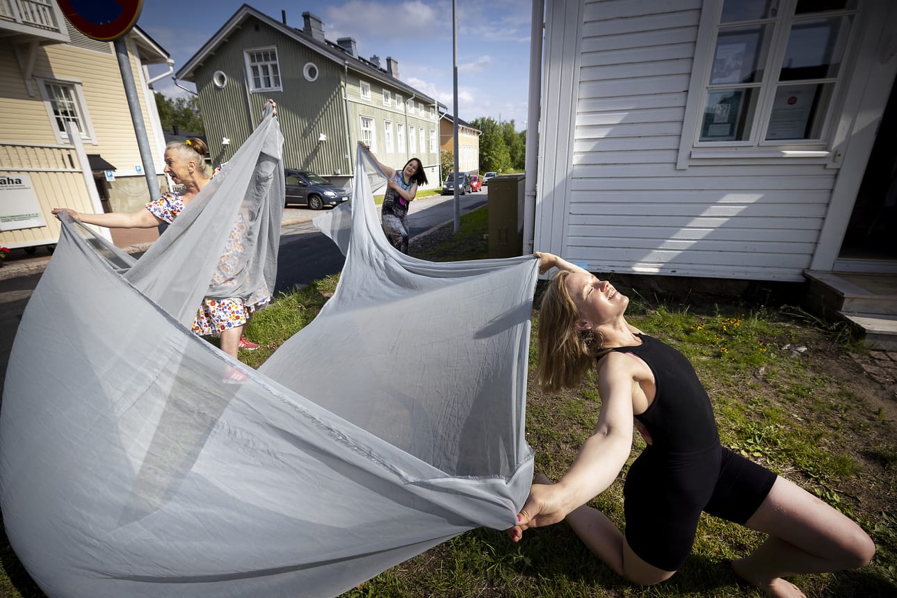 Tanssija Päivi Mettovaara esittää Pikisaaren Kelluvalla lavalla 1.7. sooloteoksen, jonka työnimi on Päästä varpaisiin. Esityksessä rekvisiittana olevaa kangasta kannattelevat Pauliina Lappi (vas.) ja Merja Männikkö Esteetön ry:stä.