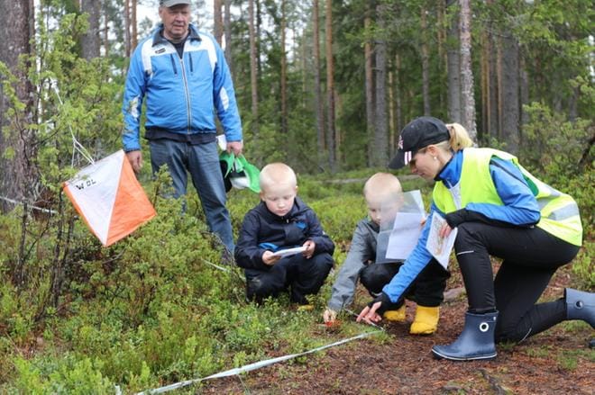 Kaksospojat Topias ja Artturi Perälä harjoittelivat sähköistä leimausta rastireittiradalla Raimo-pappansa ja suunnistuskoulun vetäjän Ulla Nivukosken tarkkaillessa tilannetta. KUVAT: HANNU LUSA