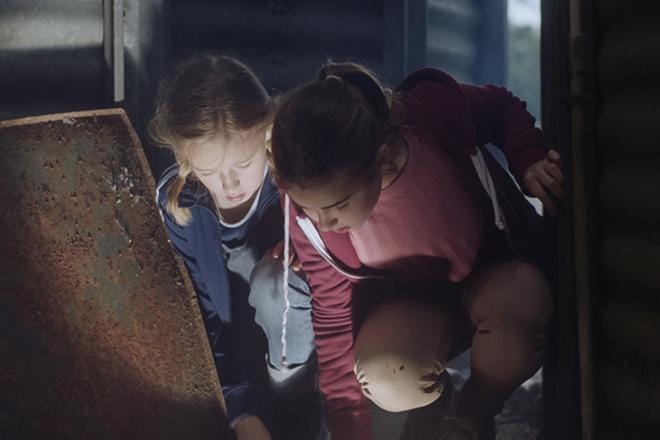 Josefinin (Nike Ringqvist) ja Nadjan (Maja Magnusson) seikkailu alkaa, kun Nadja löytää maasta valoa hehkuvan kiven. KUVA: Yle Kuvapalvelu