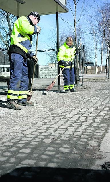 Katutyöntekijä Petri Malinen ja kunnossapitotyöntekijä Aila Paakkola puhdistivat bussipysäkkejä luudilla Kasarminkadulla Oulussa tiistaina. Käsitöihin joudutaan alueilla, joihin puhdistuskoneet eivät pä