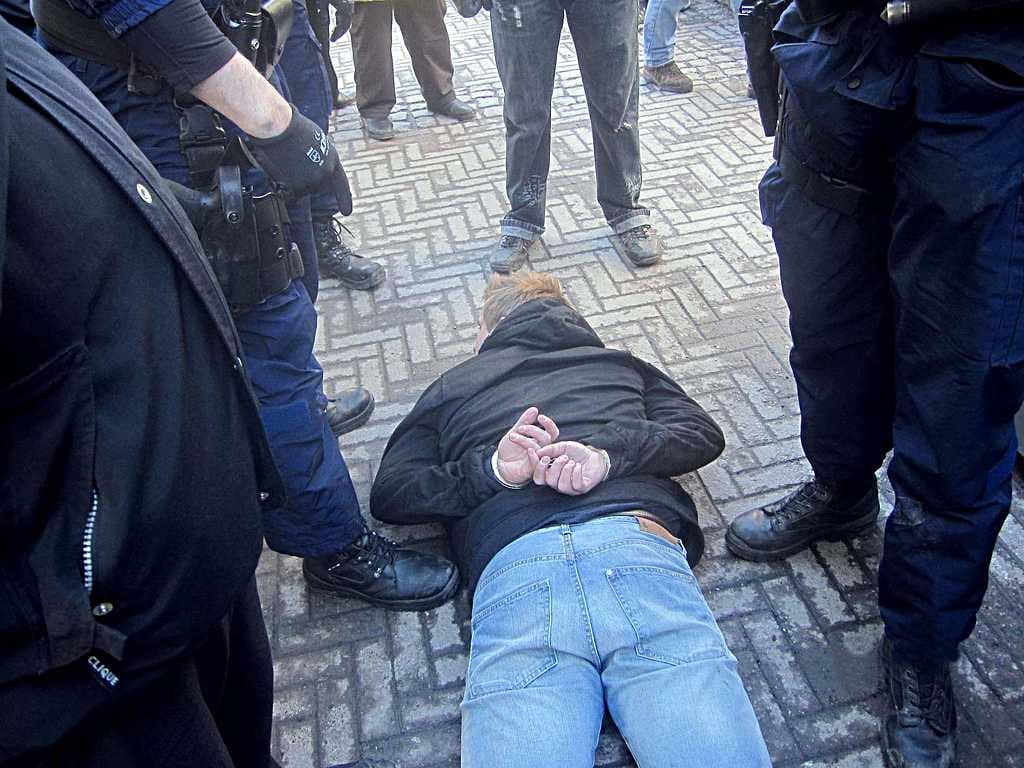 Poliisi joutui käyttämään muun muassa etälamautinta kiivastuneisiin kansanedustajaehdokkaiden kimppuun hyökänneisiin miehiin. Kuvassa yksi käsirautoihin laitetuista miehistä.