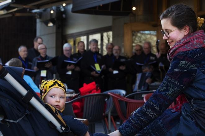 Iida Viholainen jäi poikansa Nuutin kanssa kuuntelemaan Reserviläiskuoro Vinosyötön laulua ravintolan edustalle. KUVAT: JARNO PELLINEN