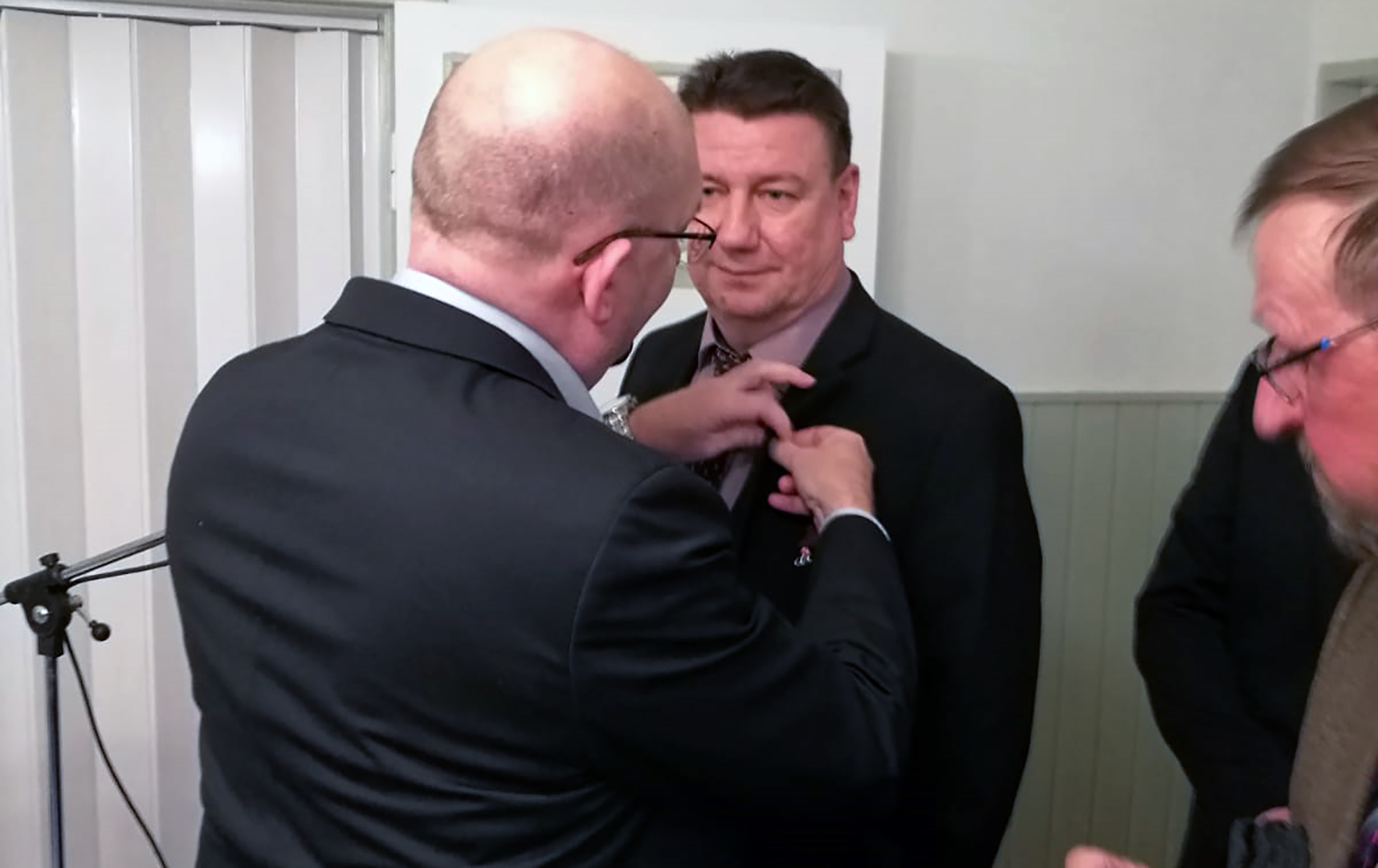 Riku Aalto kiinnitti kultaisen merkin Jari Männikön etumukseen.