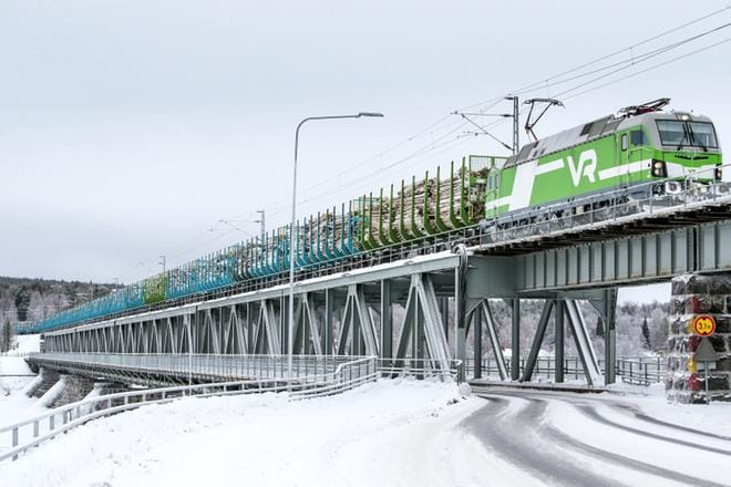 Raakapuun kuljetusjuna on ollut jo tähän asti vaikuttava näky ylittäessään Ounaskosken rautatiesiltaa Rovaniemellä. Uuden veturin myötä vaunujen määrä on kasvanut 22 vaunusta 27 vaunuun. KUVA: Anssi Jokiranta