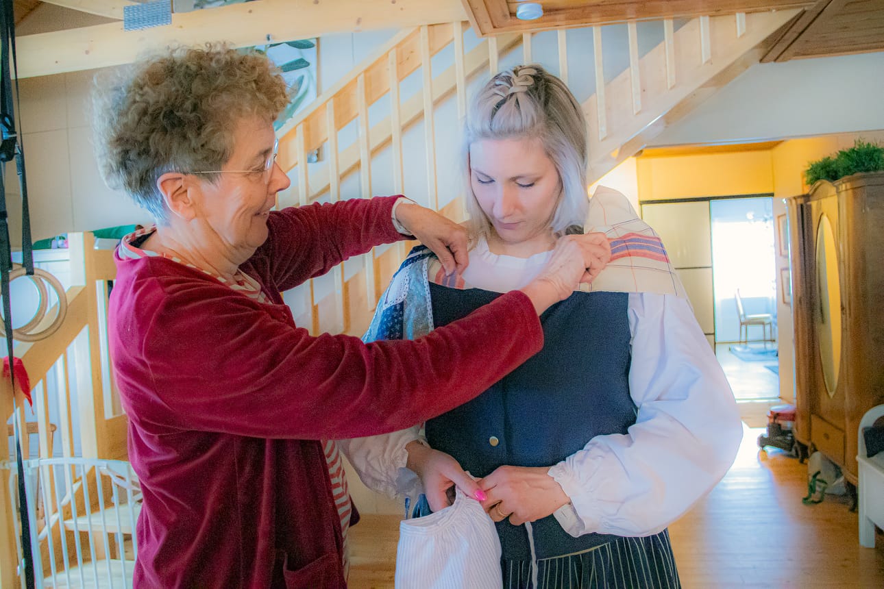 Maija Eskelinen saa äidiltään Liisa Kylmäseltä apua huivin asettelemisessa.