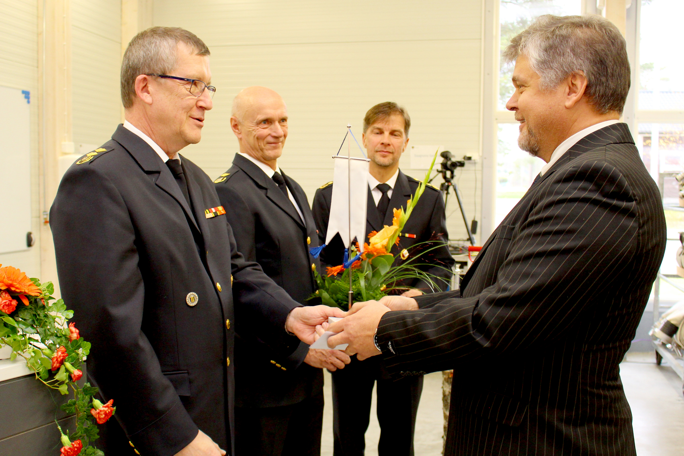 Ruukin paloaseman kalustonhoitajan toimesta heinäkuun alussa eläkkeelle jäänyttä Raimo Niinimaata muistettiin vihkijäisjuhlassa. Läksiäislahjaa luovuttamassa Jarmo Haapanen, Pekka Kankaanpää ja Kauko Himanka.
