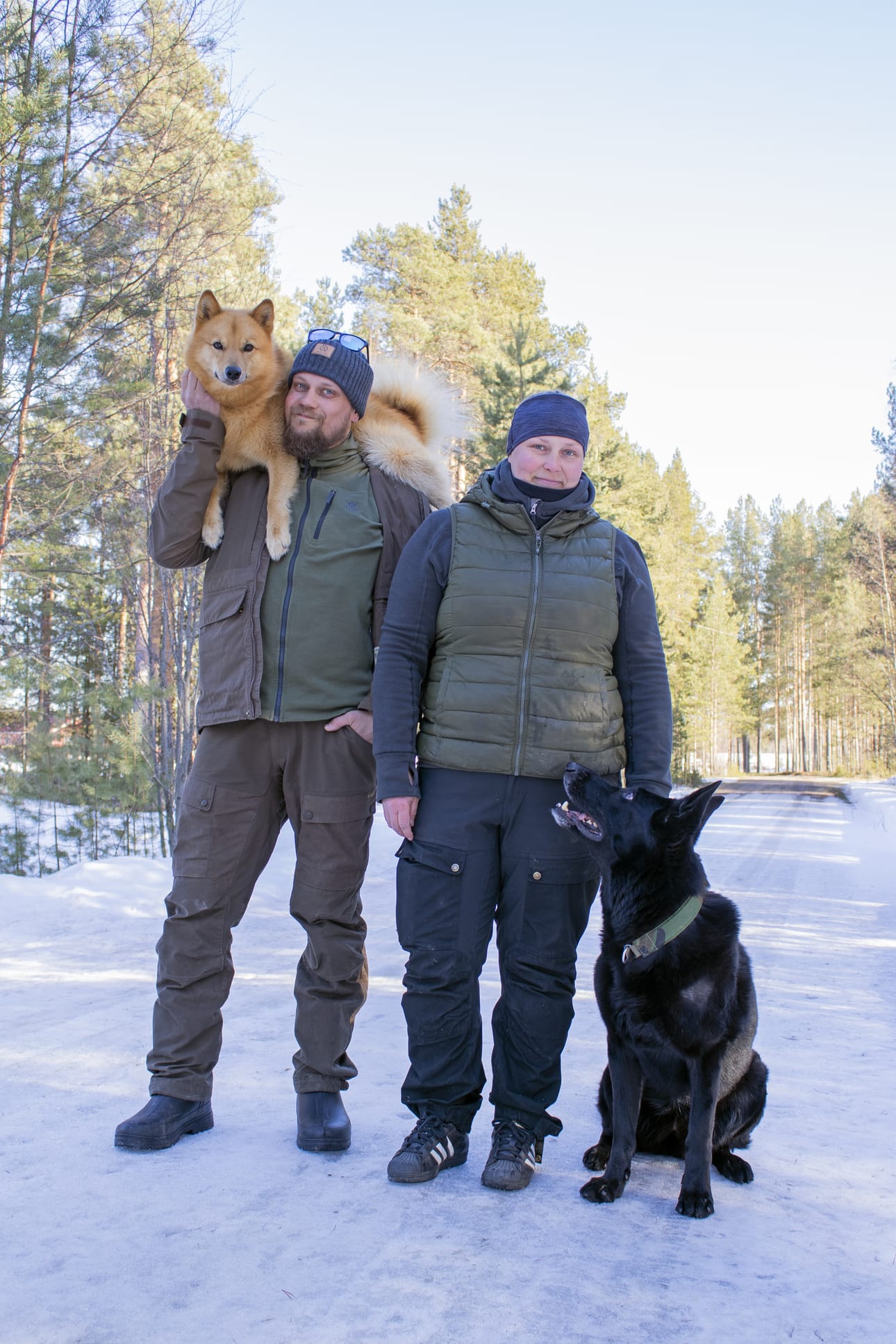 ”Jos käärme puree metsässä, niin iso koira on helpompi kantaa niskassa kuin sylissä. Siksi nämä on opetettu kiipeämään niskaan”, kertovat Simo ja Kati Väätäinen. Suomenpystykorva Roihu on suorittanut rodulle epätyypillisesti käyttäytymiskokeen ja saksanpaimenkoira Hemi kisaa SM-tasolla palveluskoiralajeissa.