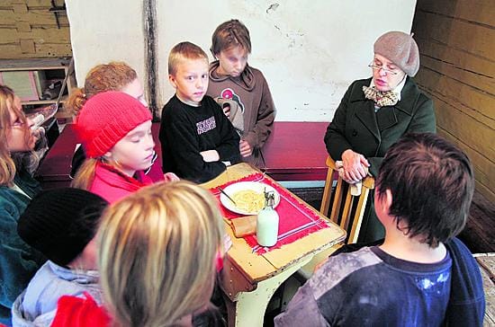 Museonhoitaja Anneli Syrjänen kertoo oppilaille, että kouluruokailun järjestäminen tuli pakolliseksi 1940-luvulla.
