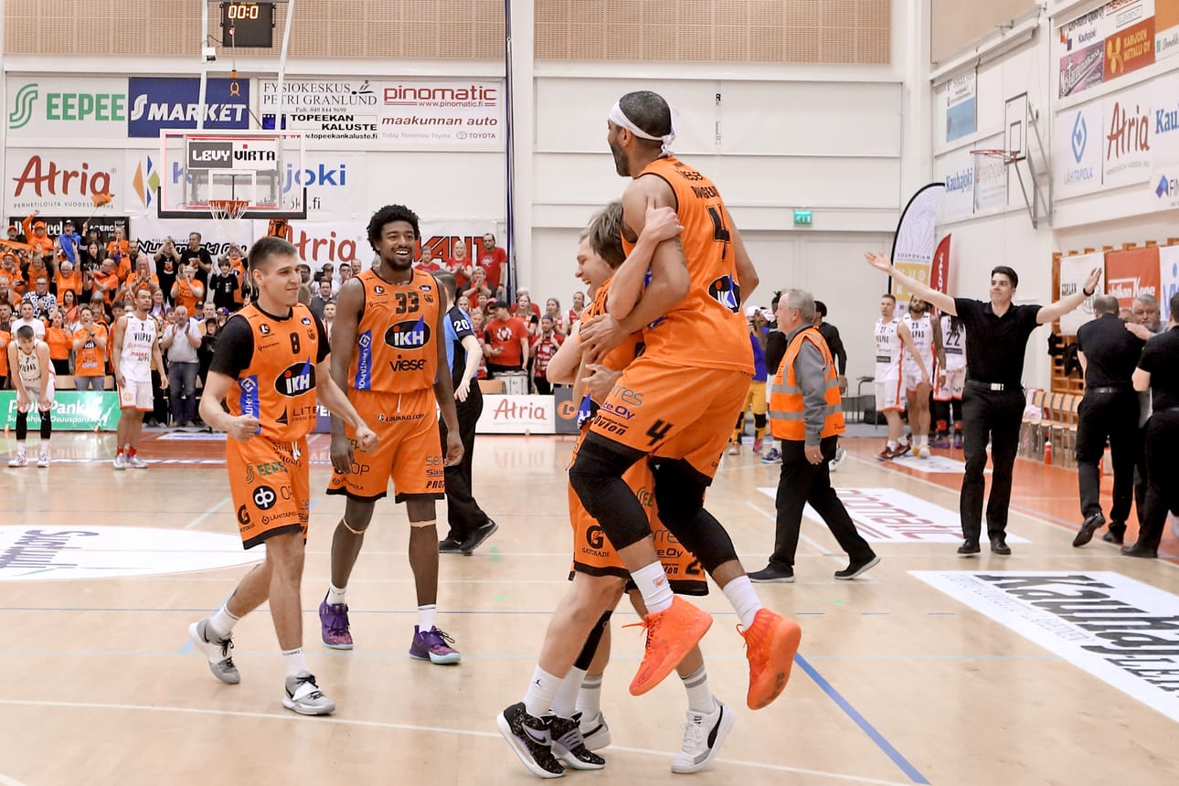 Karhu Basketin pelaajat juhlivat mestaruutta ja päävalmentaja Janne Koskimies tuuletti taustalla.