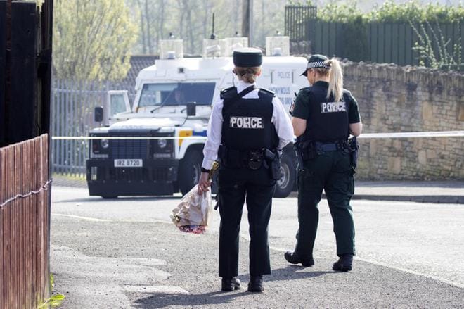 Poliisit veivät kukkia paikalle, jossa 29-vuotias toimittaja kuoli Londonderryn kaupungissa Pohjois-Irlannissa myöhään torstai-iltana. Ampujiksi epäillään yhtenäistä Irlantia ajavaa ääriryhmittymää. KUVA: JOE BOLAND / NORTH WEST NEWSPIX / EPA