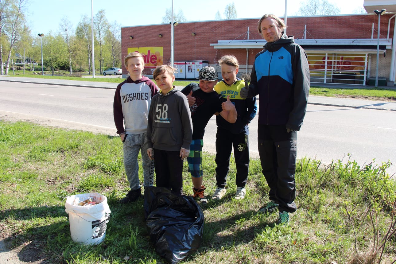 Saaren koulun nelosluokkalaiset Jesse Karkulahti (vas.), Kaijus Lehtelä, Jasper Mustonen, Oskari Salmela ja opettaja Mikko Hiitola viettivät oppitunnin Pyhäjoen keskustaa siivoten.
