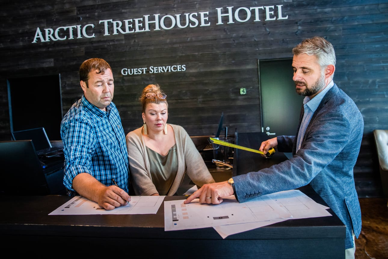 Yrittäjät Ilkka Länkinen ja Katja Ikäheimo-Länkinen sekä Arctic treehouse -hotellin hotellinjogtaja Kenneth Tuomi suunnittelevat yhdessä muutoksia hotellin vastaanottotiloihin. Vanha tiski puretaan pois, jotta tilaan saadaan väljyyttä.