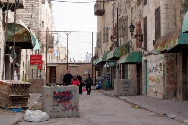 Shuhada-katu sijaitsee Hebronissa Länsirannan palestiinalaisalueella, jossa Israelin sotilasmiehitys näkyy varsin konkreettisesti arjessa. Israelilaiset ovat rajoittaneet tuntuvasti palestiinalaisten liikkumista kaupungin pääväyliin lukeutuvalla kadulla, koska sen viereen on sijoitettu yksi Israelin laittomista siirtokunnista. Shuhadan kulmat muuttuvat viikoittain taistelutantereeksi, kun palestiinalaiset mielenosoittajat ja Israelin turvallisuusjoukot ottavat yhteen. KUVA: OLLI KOIKKALAINEN