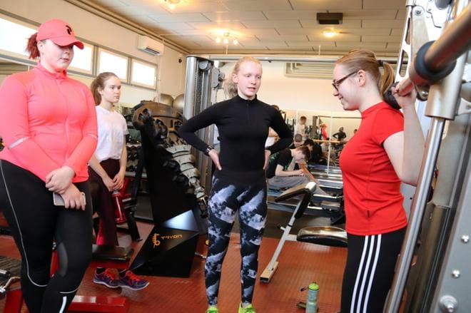 Kuntosaliharrastusta aloittava Sanna Vartio (oik.) nostaa rautaa kokeneempien saliharrastajien, Josefiina Luoma-ahon (vas.), Sanni Alatalon ja Sara Pesosen, ohjauksessa. Yhdeksäsluokkalaiset odottavat modernia kuntoilukeskusta Evijärvelle. KUVA: OUTI RANTALA