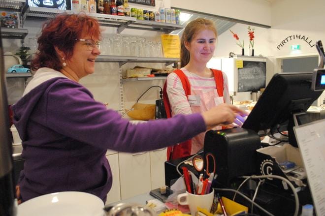Hanna Niemenmaa opastaa Mirella Siirilää kassan käytössä. KUVA: EEVA-LIISA KULJU