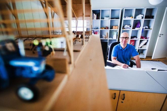 Jouni Pitkäranta työhuoneellaan. Etualalla arkkitehtiopintojen aikainen diplomityö, pienoismalli täysin puurakenteisesta pihattonavetasta.