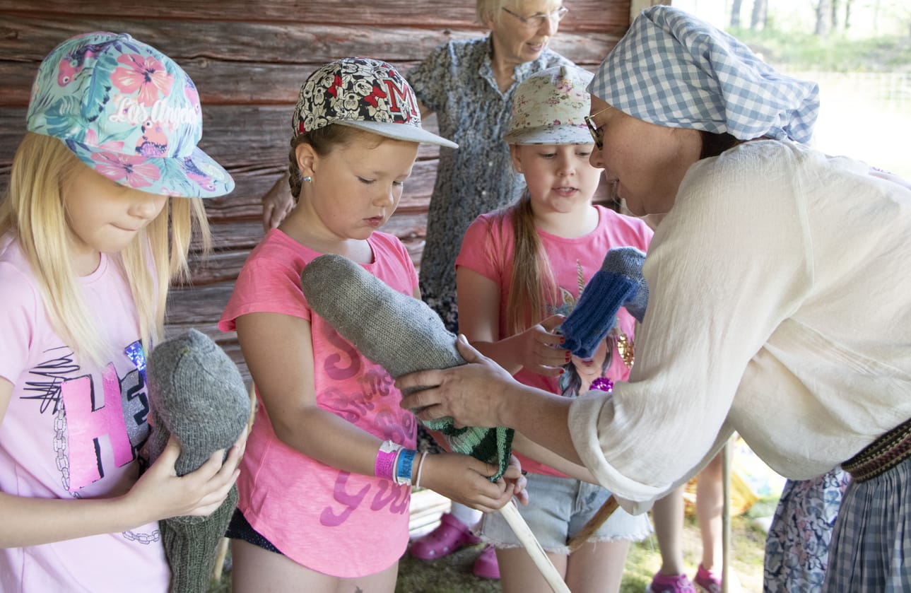 Vappu Hietala, Iiris Haukipuro ja Miina Hietala saivat Kirsi Träskeliniltä apua kepparihevosen kepin kiinnittämisen.
