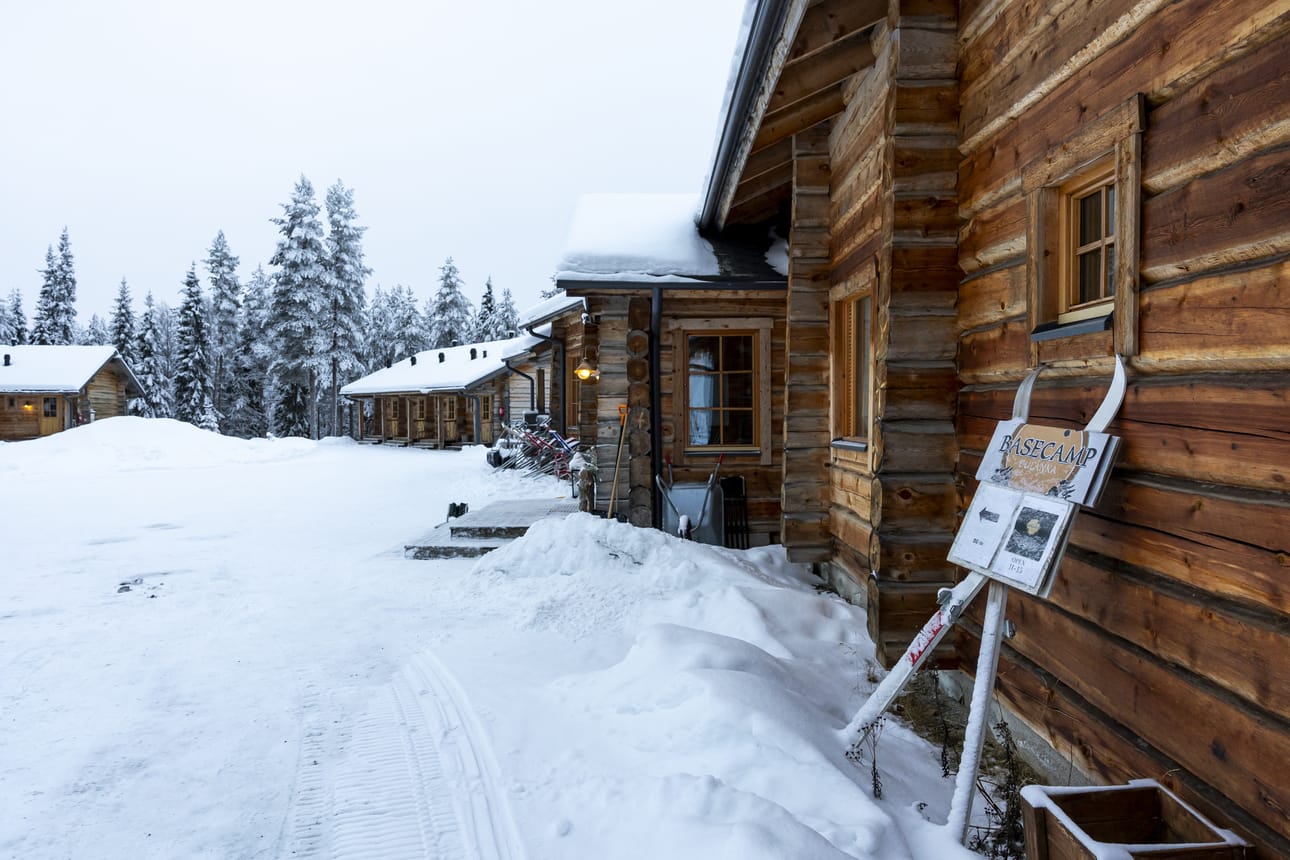 Basecamp Oulangan päärakennus (oik.) ja majoitusrakennukset ovat Oulangan kansallispuiston rajasta ja Pienen Karhunkierroksen reitiltä vain noin sadan metrin päässä. Toisella puolella on Ala-Juumajärvi.