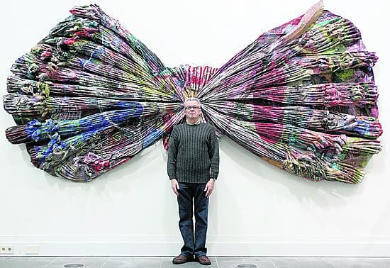 Reijo Hukkanen sanoo leikittelevänsä ja revittelevänsä, mutta älyllinen puoli on aina mukana. Taiteilija seisoo pellistä ja akryylistä 1986 tehdyn Avosyli-teoksensa edessä Oulun taidemuseossa.