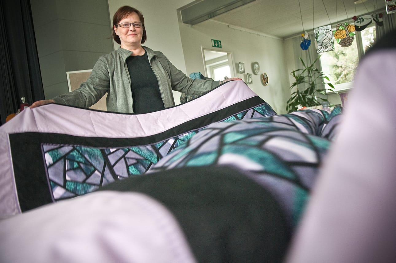 Maire Raatesalmi etsi Marja-Leena Lampisen tilkkutyölle paikkaa näyttelystä. Piirissä pidettiin töiden valmistuttua ristiäisiä. Tämän peitteen nimi on Vanhat verhot.