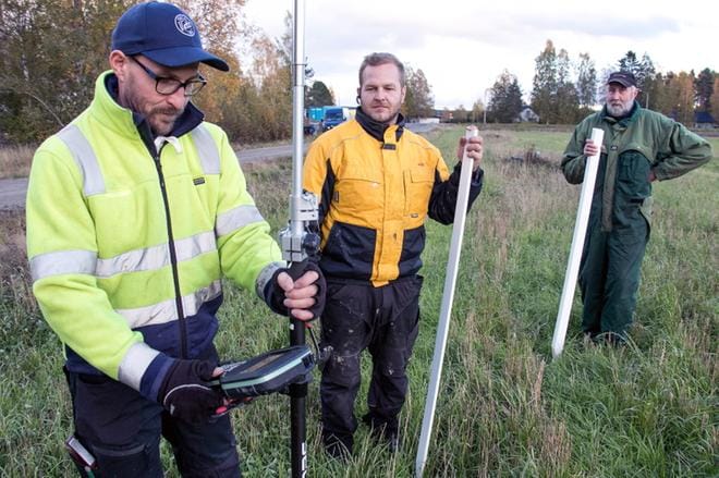 Maanmittaaja Harri Erkkilä (vas.), Jani-Pekka Hannula ja Into Sahakoski merkitsivät omakotitontin rajoja Karijoen kirkonkylässä viime viikolla. Hannula kertoi, että talopaketti on tilattu, ja tulee viikolla kaksi ensi vuonna. KUVA: JORMA HAVULA