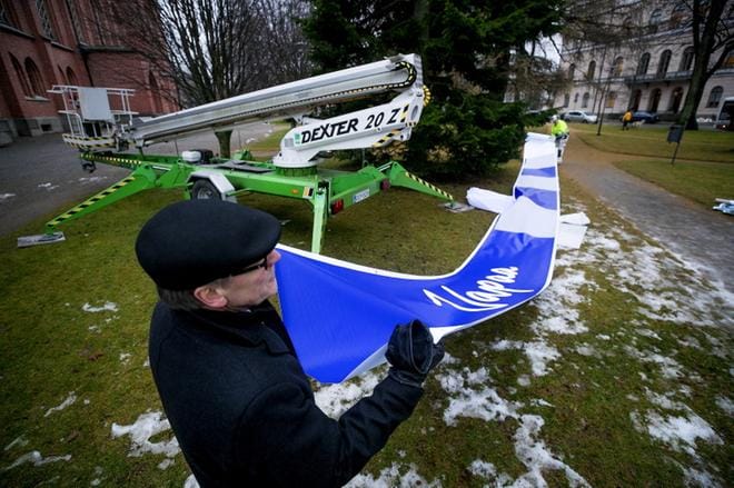 Kirkon edessä oleva kuusi sai ylleen yhteensä 25 metriä veteraaninauhaa. Seurakuntayhtymän kiinteistöpäällikkö Mikko Päällysaho oli mukana koristelemassa juhlakuusta. KUVA: JAAKKO ELENIUS