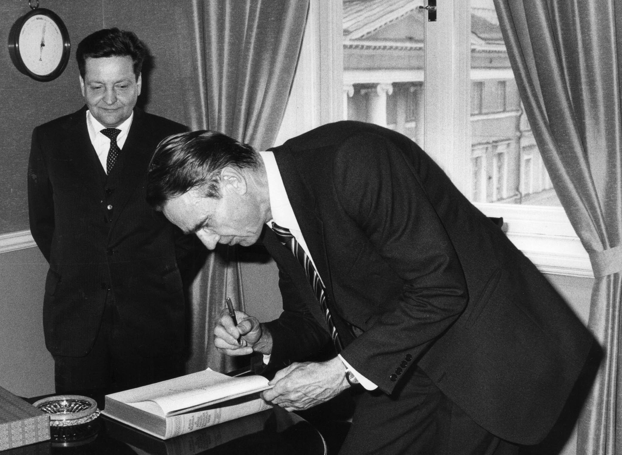 Pääministeri Mauno Koivisto kirjoitti Juhla-Kalevalan luovutuksessa nimikirjoituksensa teoksen kansilehdelle vuonna 1981. Kuvassa myös kirjan luovuttanut Tampereen Kirjapaino Oy:n toimitusjohtaja Timo Laatunen.