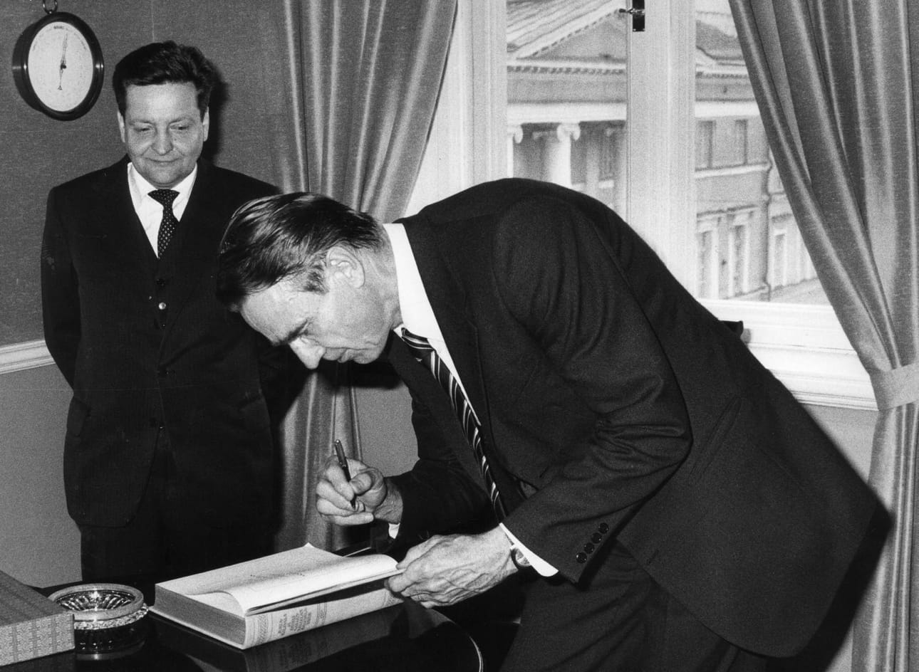 Pääministeri Mauno Koivisto kirjoitti Juhla-Kalevalan luovutuksessa nimikirjoituksensa teoksen kansilehdelle vuonna 1981. Kuvassa myös kirjan luovuttanut Tampereen Kirjapaino Oy:n toimitusjohtaja Timo Laatunen.