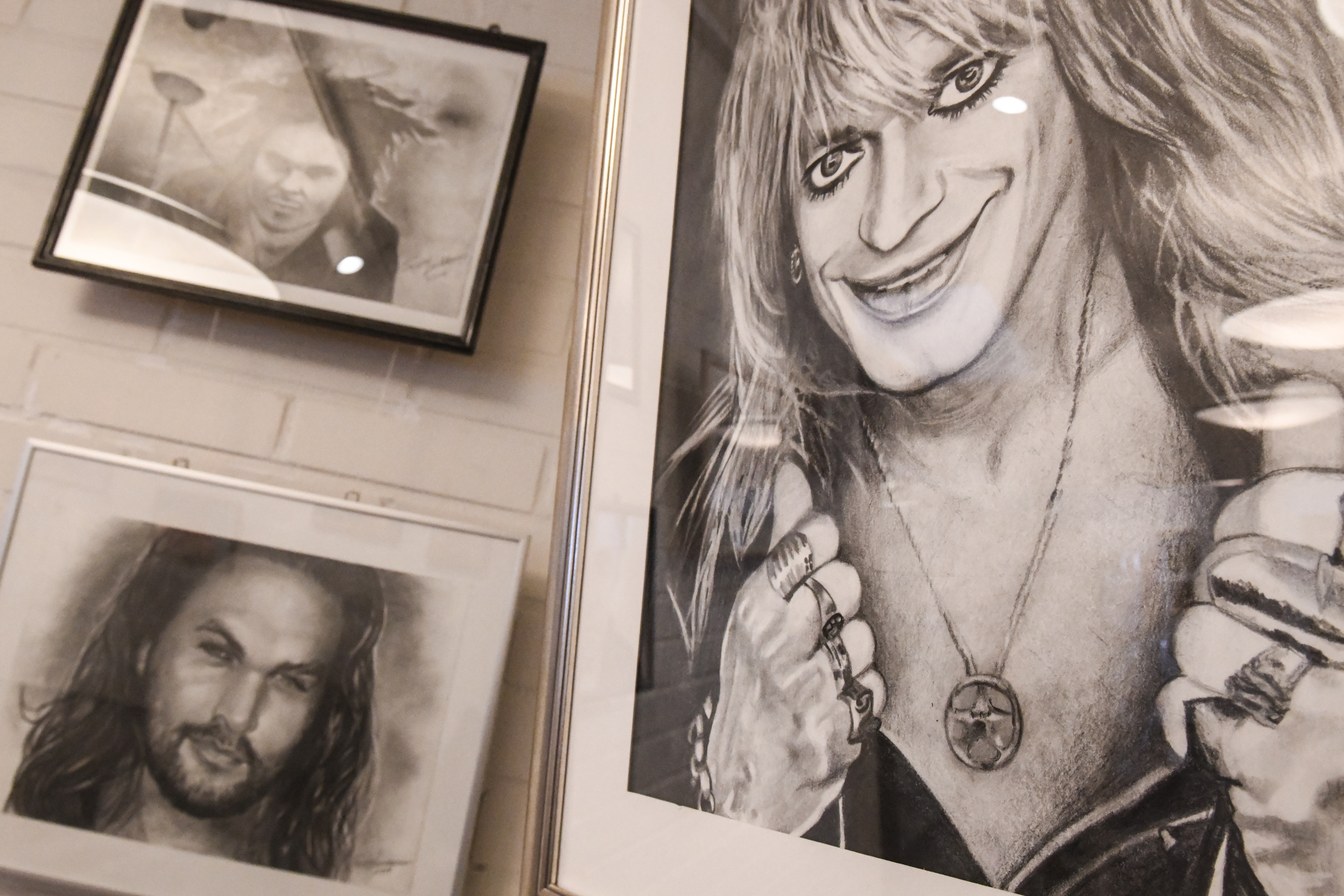 Lauri Ylönen, Jason Momoa ja Michael Monroe Luukkosen lyijykynällä maalatuissa tauluissa.