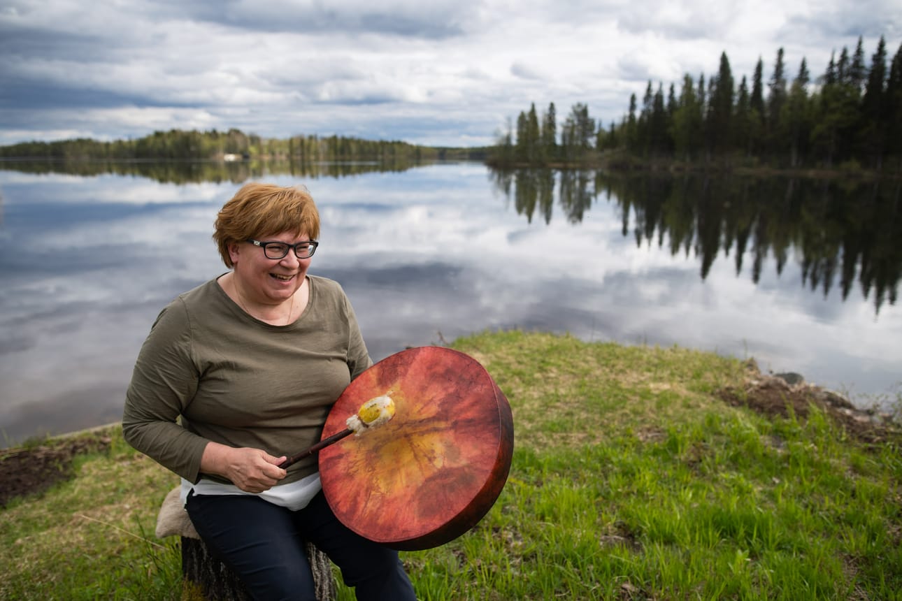 Vuotunkilainen Ulla Tasala kotitalonsa rannassa. Tasala on yrittäjä, joka antaa vyöhyketerapiaa ja pitää rumpumeditaatiota. Kuvan Lapinrummun Tasala on tehnyt kyläyhteisön toiminnassa.