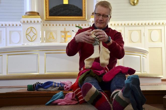 Jarkko Siekkisellä on muutama sukkapari jäljellä Pappilan kamarin naisten kutomista sukista. Niitä jaettiin viime vuonna 20 ja 30 vuotta täyttäneille seurakuntalaisille. KUVA: HANNELE YLI-VIITALA