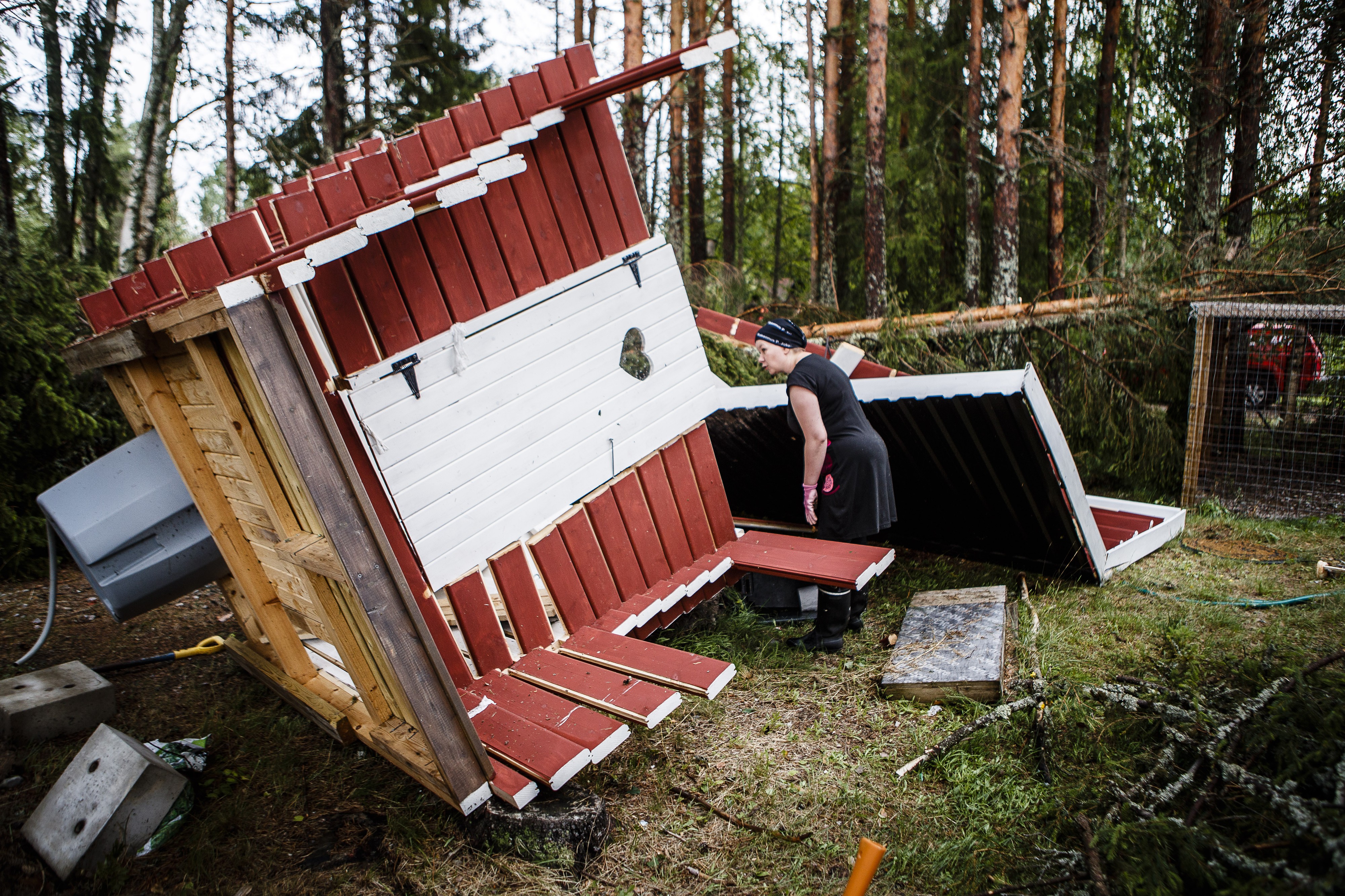 Kuuseloiden pihapiirissä Rautiosaaressa kaatui paljon puita, mutta onneksi vain huussi sai osuman. Linda Kuusela tarkastelee huussin kärsimiä vaurioita.