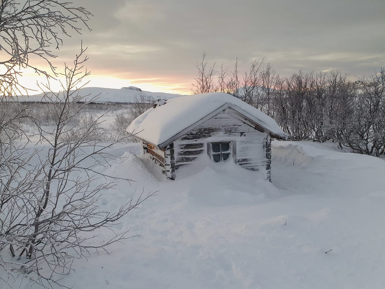 Lumivallit ympäröivät Jogasjärven kämppää Enontekiöllä. Talvivaelluksilla on varauduttava siihen, että kämpän ovi tai savupiippu on saattanut tuiskuttaa umpeen.