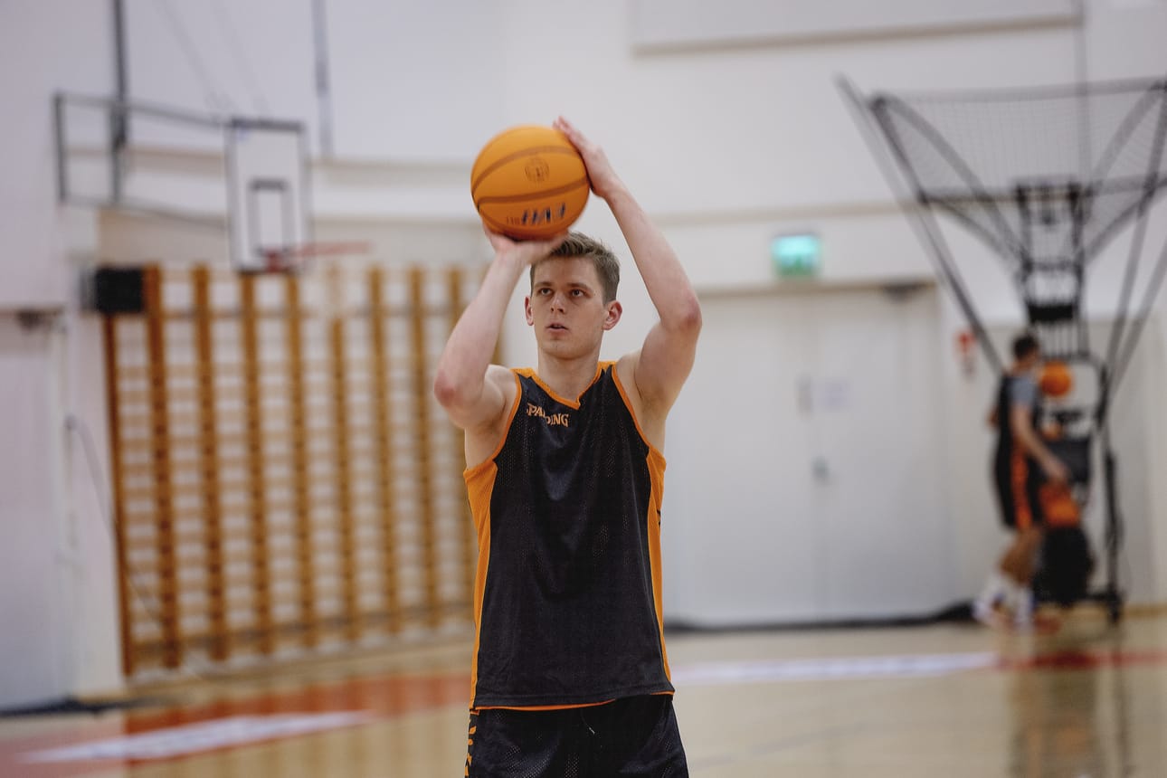 Sinivalkoinen Susijengi-paita on vaihtunut oranssimustaan Karhu Basketin asuun. Henri Kantonen heitteli palloa koriin ennen harjoitusten alkamista koulukeskuksen liikuntahallissa maanantaina.