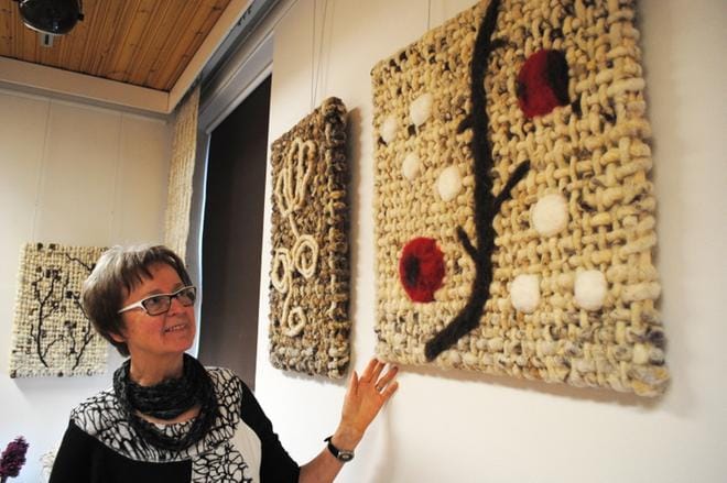 Auli Haapala esittelee taulua, jossa on käytetty erikoista, vahvaa villalankaa. KUVA: EEVA-LIISA KULJU