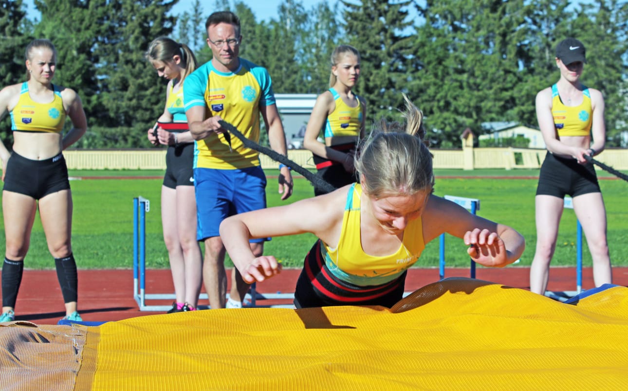 Patrik Mattsson valmentaa Niittomiesten pikajuoksijoita ja hyppääjiä. Yhteisharjoituksissa urheilukentällä riittää säpinää. Kuvassa patjalle on heittäytymässä Ella Nissinaho.