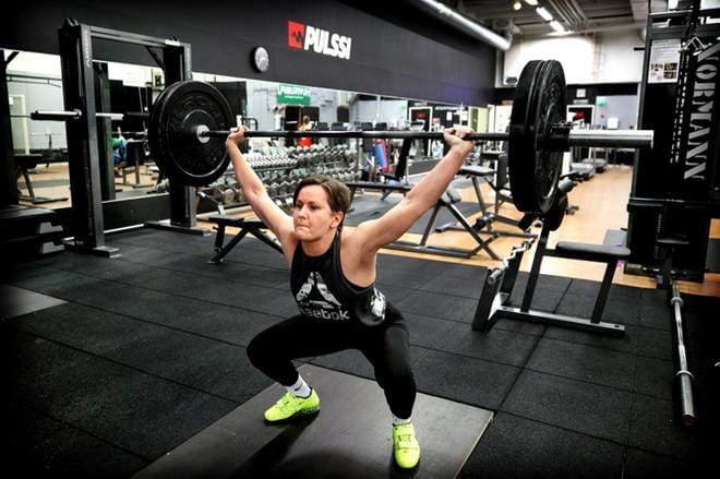 Anja Palomäki harjoittelee tempausta, joka on yksi painonnoston kolmesta liikkeestä. Painonnostajalle on tärkeää, että salilla alusta ja välineet ovat sellaiset, että painon voi antaa pudota maahan. KUVA: JOUKO HÄNNINEN